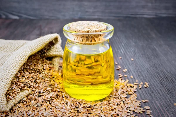 Aceite de linaza con semillas en tablero oscuro — Foto de Stock