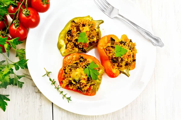 Pimienta con champiñones y cuscús en plato sobre tabla ligera — Foto de Stock