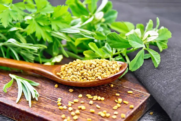 Fenugreek in spoon with herbs on board — Stock Photo, Image
