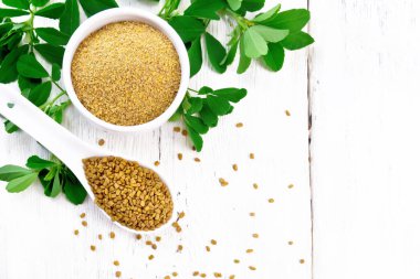 Kaşık ve kase içinde üstünde yapraklar olan bir FenuGreek.