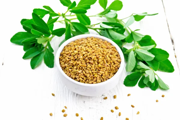 Fenugreek with green leaves in bowl on board — Stock Photo, Image
