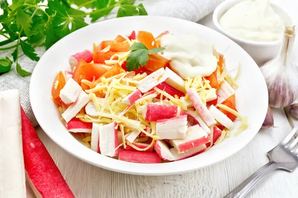 Салат из сурими и помидоров на светлой доске — стоковое фото