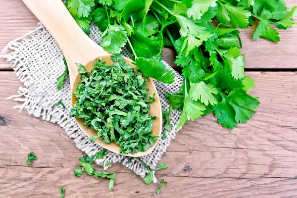 Cilantro dried in spoon on old board top — Stock Photo, Image