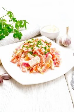 Salad of surimi and tomatoes with mayonnaise on wooden board