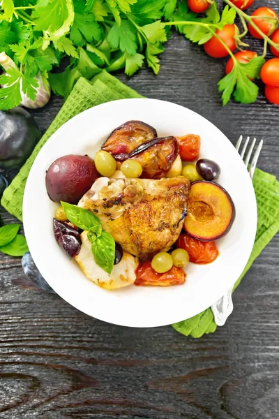 Frango com frutas e tomates em prato no topo da placa escura — Fotografia de Stock