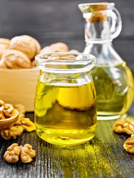 Oil walnut in jar and decanter on wooden board — Stockfoto