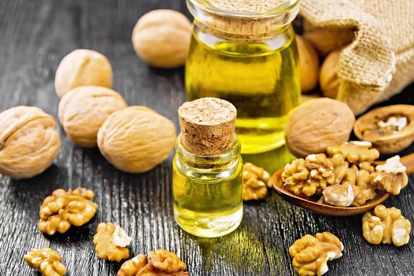 Oil walnut in two jars on board — Stock Photo, Image