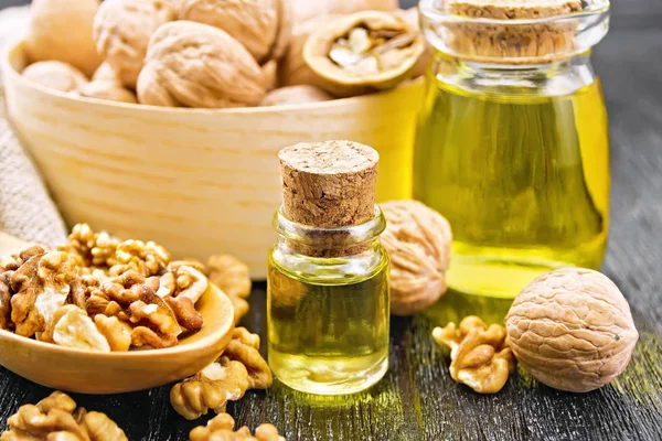 Oil walnut in two jars with spoon on board — Stok fotoğraf