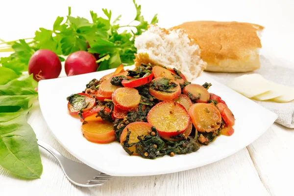 Rábano con espinacas y especias en plato sobre tabla de madera clara — Foto de Stock