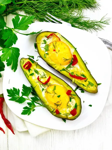 Яичница с перцем в авокадо на светлой доске — стоковое фото