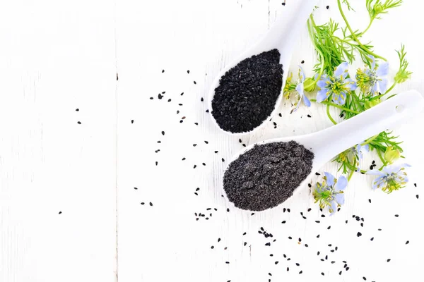 Nigella Sativa Tohumları Iki Kaşıkta Mavi Çiçekli Yeşil Yapraklı Kalingini — Stok fotoğraf