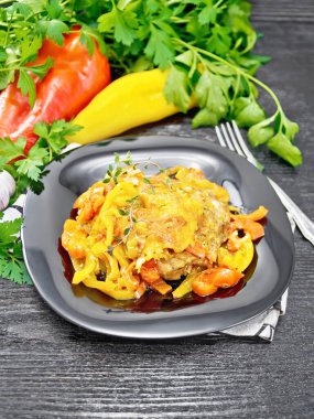 Domatesli tavuk, peçete, kekik, maydanoz ve ahşap arka planda sarımsak tabağında sarı ve kırmızı dolma biber ve peynir.