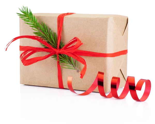 De gift van Kerstmis in kraftpapier gebonden rode vlecht en pine tree branc — Stockfoto