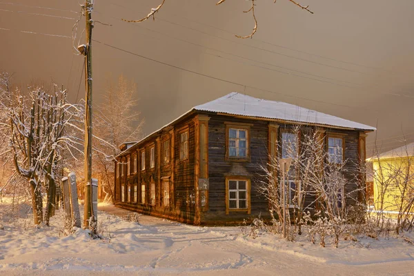 Old wooden house on a snowy frosty street in night illumination — Stock Photo, Image