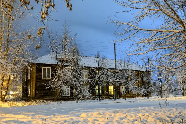 Vieille maison en bois sur une rue givrée enneigée en éclairage nocturne — Photo