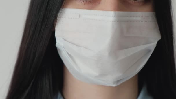 Yüzüne tıbbi maske takmış, kameraya bakan güzel bir kadın. Maskeli Avrupalı bir kadın. Coronavirus covid 19 salgını. Ameliyata hazır.. — Stok video