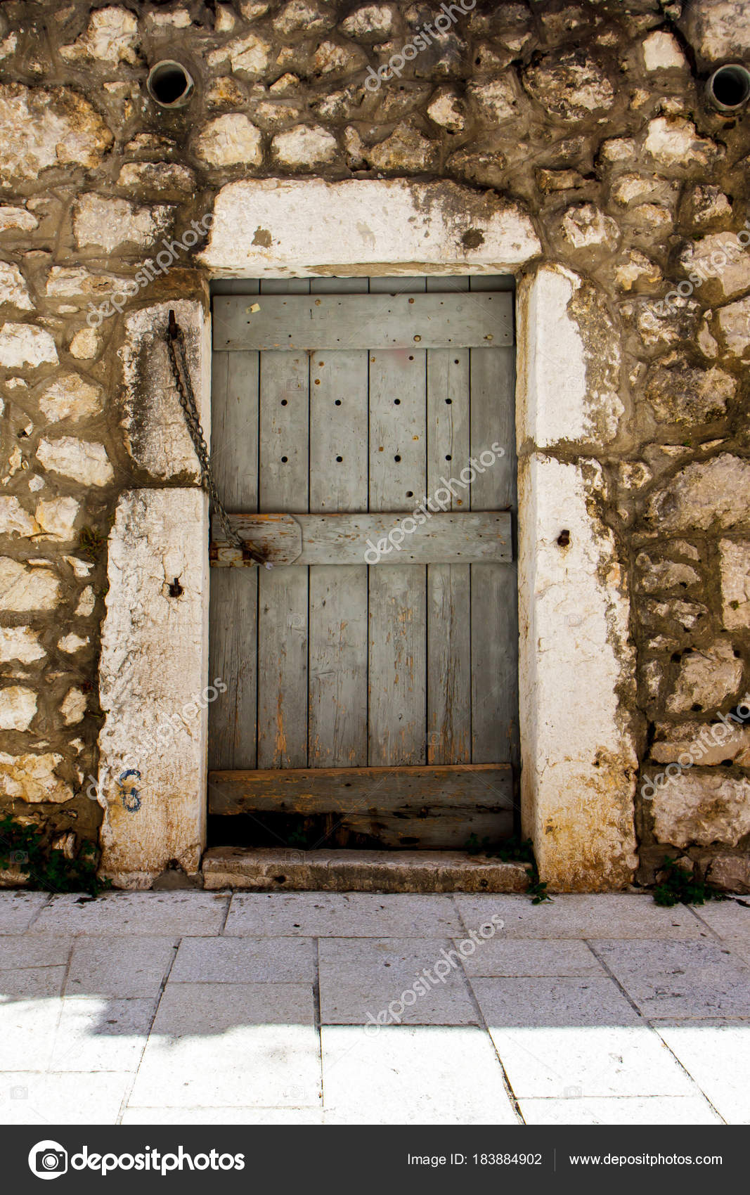 Frammento della facciata di una casa in pietra con una porta in ... Facciata casa in pietra
