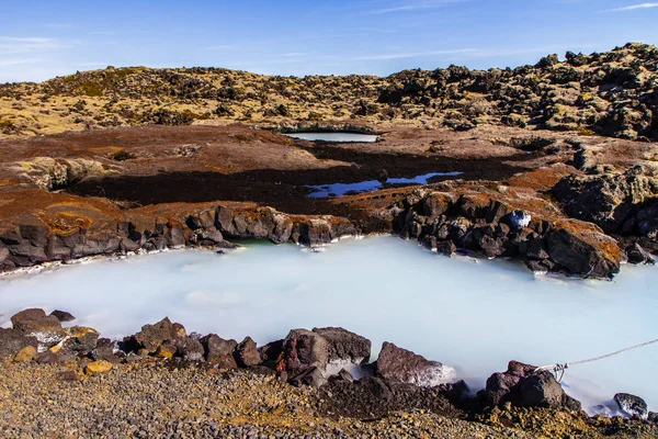 Orilla rocosa y lago del cráter en Islandia. Vista lateral de la laguna azul —  Fotos de Stock