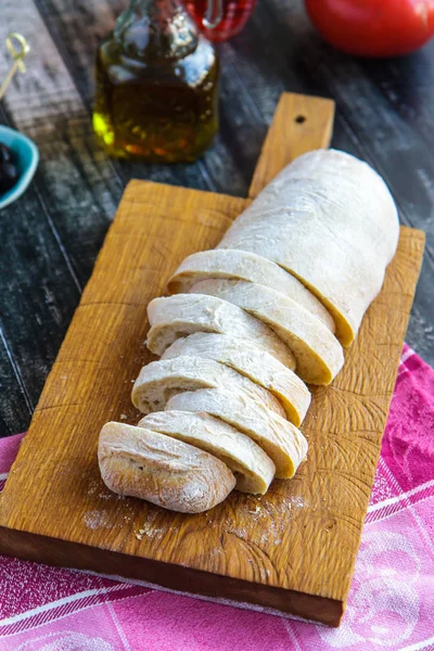 Pedaços de chiabats numa tábua de corte. Pão italiano — Fotografia de Stock