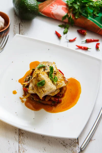 Balıklar Basque içinde pişmiş, avokado ve limon görünümü top. Fransız mutfağı