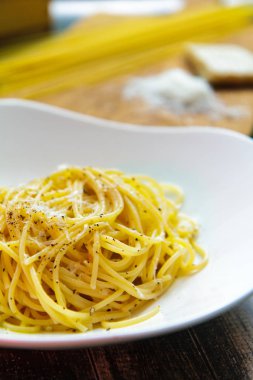 Bir seramik tabak yan görünümünde peynirli erişte