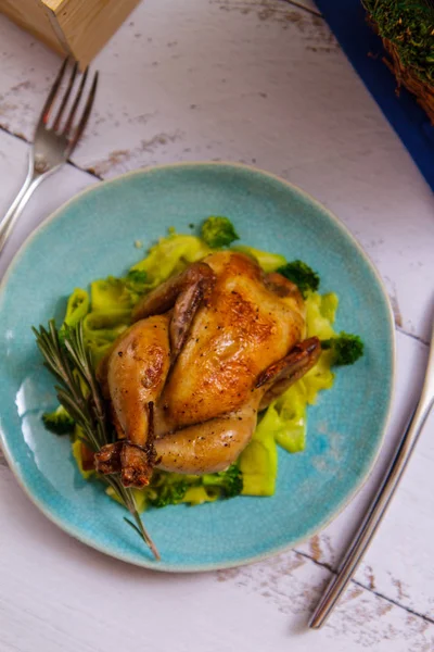 Fried chicken with rosemary and broccoli on a blue plate top view — Stock Photo, Image