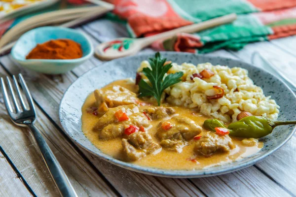 Paprikas de pollo con guarnición en un plato de cerámica Imágenes de stock libres de derechos