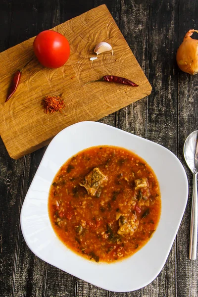 오래 된 보드에 흰색 접시에 토마토 수프 — 스톡 사진