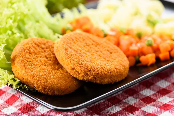 Hamburger di pesce circondati da lattuga su un piatto — Foto Stock