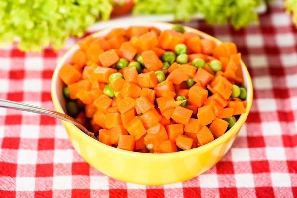 Guisantes y zanahorias en una cuchara — Foto de Stock