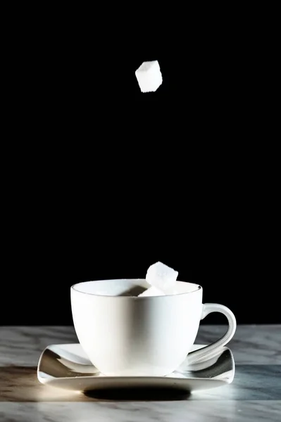 Sugar cubes thrown into a cup of coffee — Stock Photo, Image