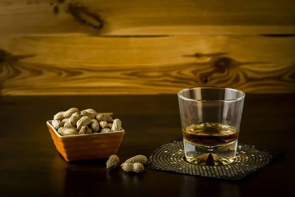 Whiskey och en skål med jordnötter — Stockfoto