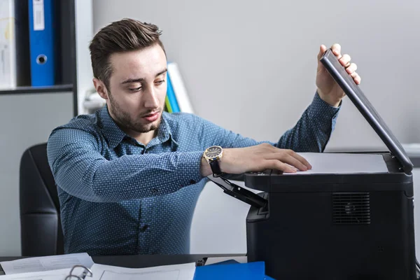 De werknemer ondersteunt multifunctionele machine — Stockfoto