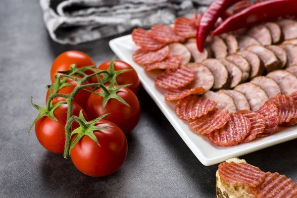 A plate of sliced cold meats - delicious smoked sausage and spic — Stock Photo, Image