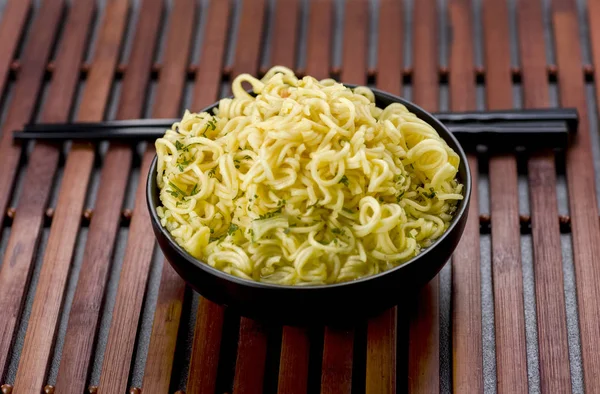 Noedels in een kom met de Bouillon en eetstokjes — Stockfoto