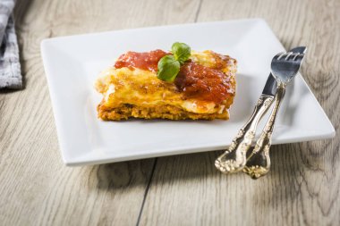 Lazanya domates soslu beyaz tabakta iştah açıcı bölümü