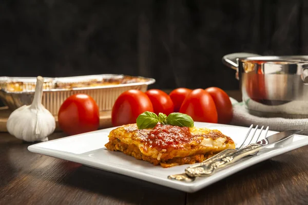 Smakelijk gedeelte van lasagne op een witte plaat met tomatensaus — Stockfoto