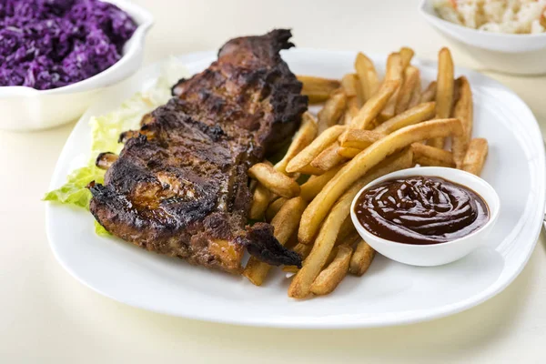 baked ribs and French fries and cabbage salad