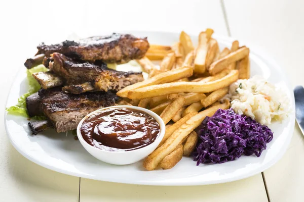 baked ribs and French fries and cabbage salad