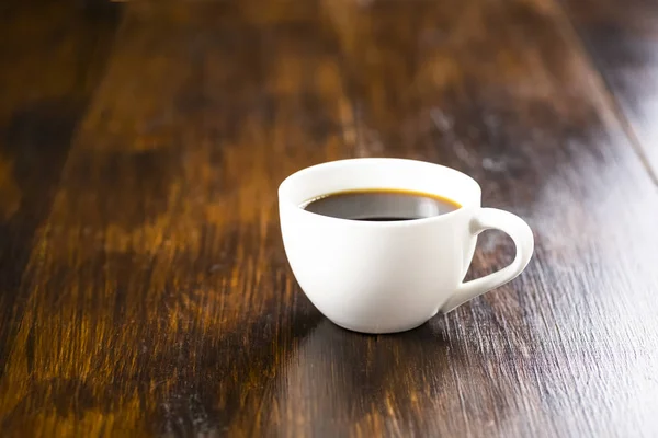 A cup of black coffee on a wooden table, — Stock Photo, Image