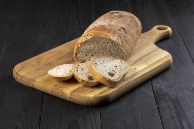 Tahta bir mutfak masasında ekmek doğrayıcı bir fotoğraf.