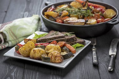 Ev yapımı yemek. Pişmiş sebzelerle çevrili taze otlarla kızartılmış biftek.