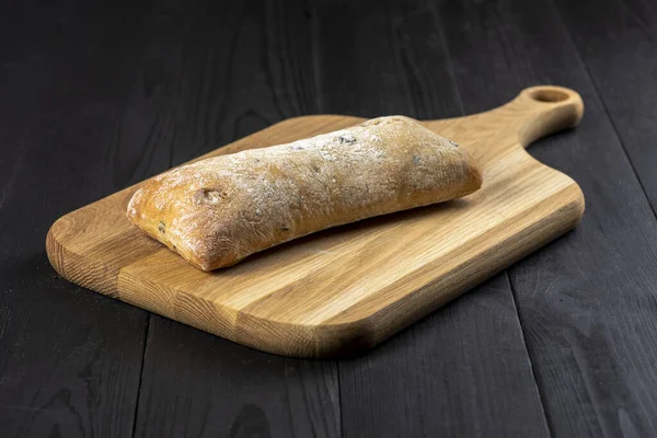 bread on a chopping board on a wooden kitchen table - rustic style photo