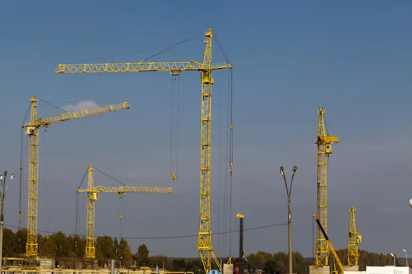 Yellow cranes on construction site against the sky — Stock fotografie