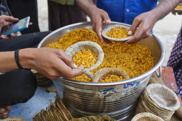 Distribuição gratuita de alimentos na Índia. prasadam sagrado em uma panela em chapas em mãos — Fotografia de Stock