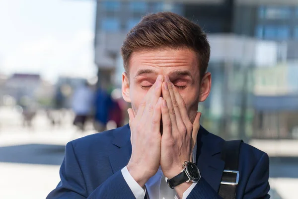 Joven en traje gerente estornuda en la calle cubriendo su fac — Foto de Stock