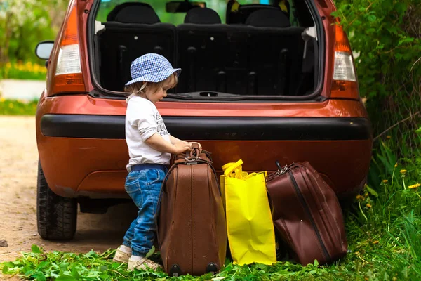 Dziecko stawia walizkę w samochodzie — Zdjęcie stockowe