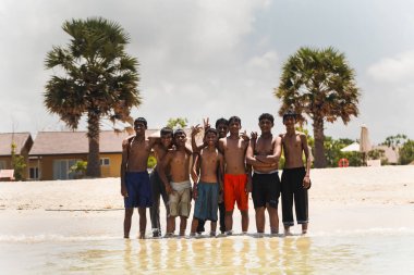 Pasikuda sahilde bir dinlenme için poz Asyalılar gençler. Sri Lanka