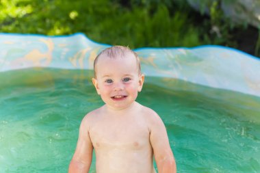 Bebek doğa bir plastik havuzunda yüzüyor