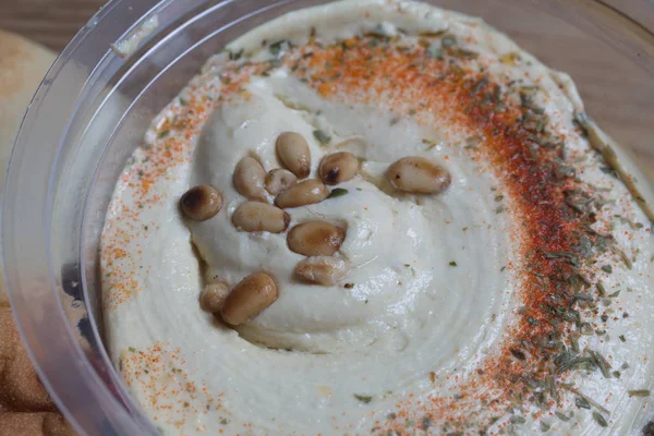Hummus con nueces de cedro en el frasco y pita fresca —  Fotos de Stock